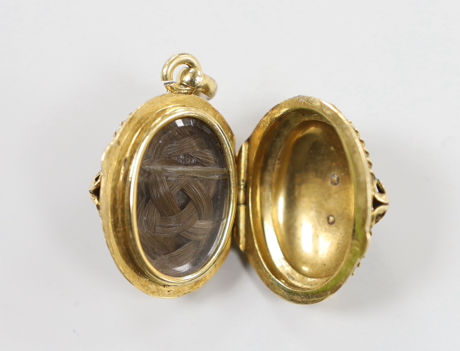 A 1940's? yellow metal and bloodstone set egg shaped mourning pendant, with rose cut diamond set star motif and plaited hair interior, overall 28mm.